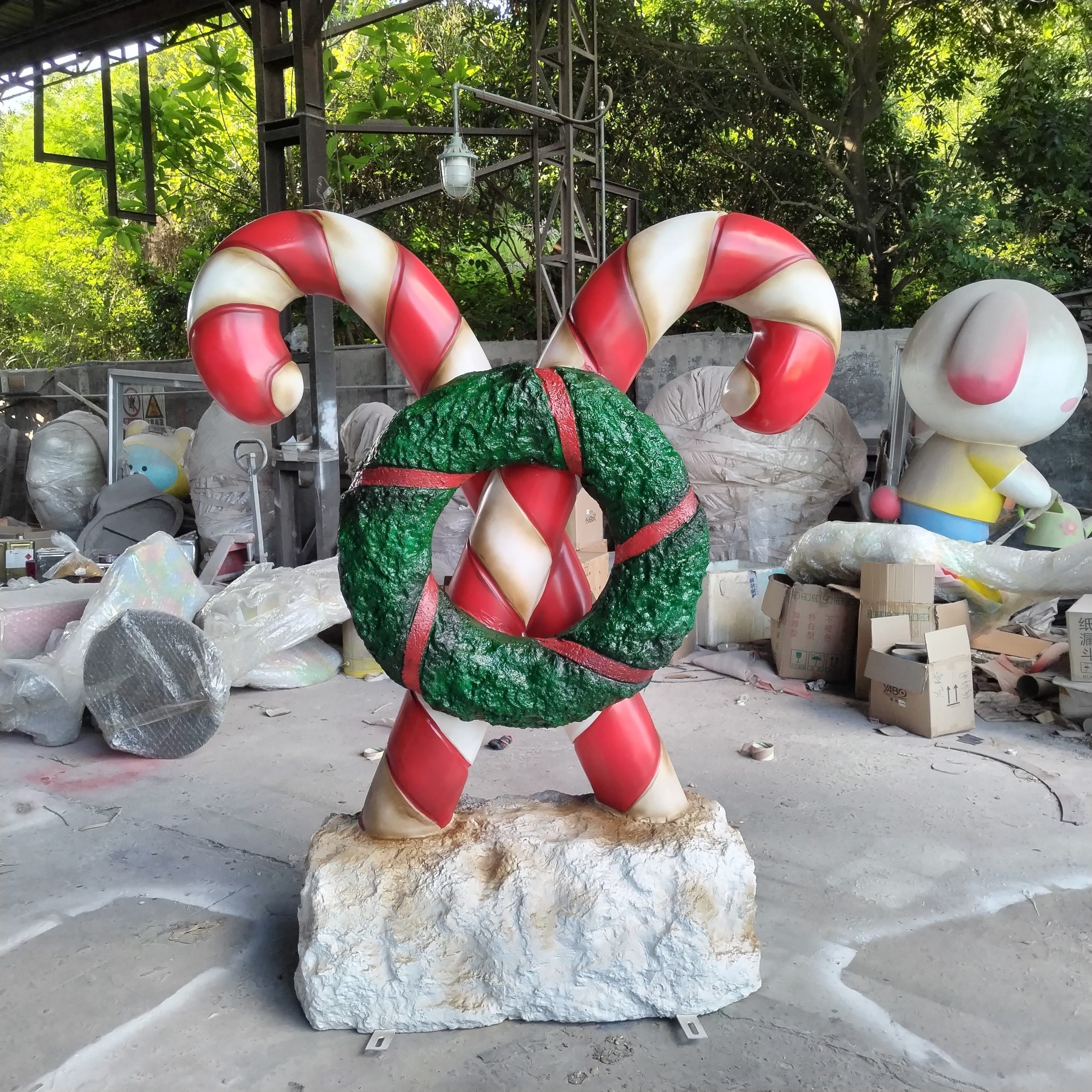 Tượng Cây Kẹo Gậy Candy Cane Composite Khổng Lồ Có Vòng Hoa Trang Trí Giáng Sinh Tượng Cây Kẹo Gậy Candy Cane Composite Khổng Lồ Có Vòng Hoa Trang Trí Giáng Sinh — góc nhìn thực tế từ xưởng sản xuất composite